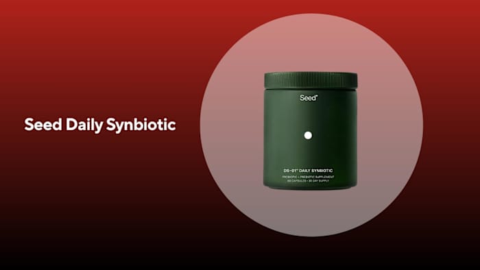 A green bottle of seed daily synbiotic against a red background